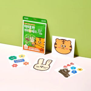 May include: A green product packaging pouch labeled with Korean text and a cartoon tiger, accompanied by four individual sticker sheets featuring a tiger face, a rabbit outline, a black cat, and various colorful floral and heart shapes.