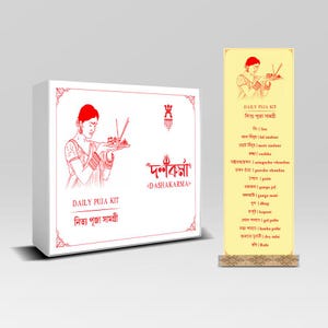 May include: A white box and a yellow stand with red illustrations and text. The box reads "DAILY PUJA KIT" and "DASHAKARMA" in English and Bengali. The stand lists items for a daily puja, including sindoor and chandan.