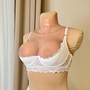 May include: White lace lingerie set with a plunging neckline and delicate floral pattern.
