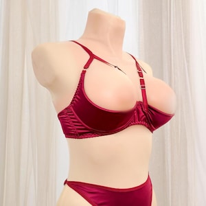Op de afbeelding: Een lingerie set van bordeaux satijn met een diep decolleté en verstelbare bandjes.