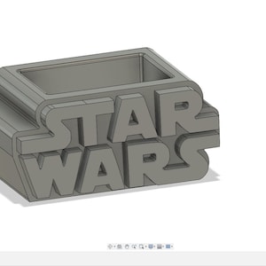 Può includere: Un vaso da fiori grigio stampato in 3D a forma del logo di Star Wars. Il vaso ha un'apertura rettangolare nella parte superiore per la semina.