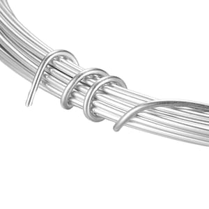 May include: A close-up of a bundle of silver-coloured wire, twisted together. The wire is smooth and shiny, and it is coiled into a tight spiral.
