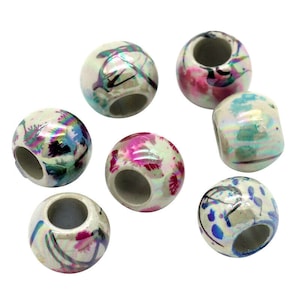 May include: Seven round ceramic beads with a white base and colourful abstract designs. The beads have a hole in the centre for stringing.