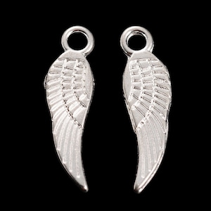 May include: Two silver angel wing charms with a loop at the top for attaching to jewellery or other crafts.