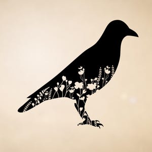 May include: A black silhouette of a crow with white floral and plant details filling the body. The crow is standing on a light beige background. The design is simple and elegant, suitable for wall art or decorative items.