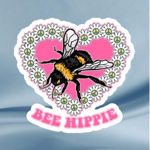 May include: A sticker featuring a black and yellow bee with white wings, centered on a pink heart. The heart is surrounded by white daisies with peace signs. The words "BEE HIPPIE" are written in pink below the heart.