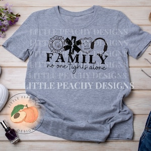 Puede incluir: Camiseta gris con un gráfico negro de símbolos de bombero, policía y EMT. El texto "FAMILY no one fights alone" está impreso debajo de los símbolos.