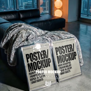 May include: Two framed poster mockups with the text "POSTER/MOCKUP" in a modern font. The frames are on a black leather couch with a faux fur throw. The posters are labeled "FRAME MOCKUP PSD" and "PREMIUM WALL ART".