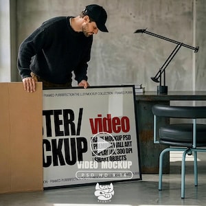 May include: A large rectangular black frame containing a white poster with bold black text reading POSTER/MOCKUP and red text reading video. The poster includes additional text: FRAME MOCKUP PSD PREMIUM WALL ART DISPLAY 4K 300 DPI SMART OBJECTS.