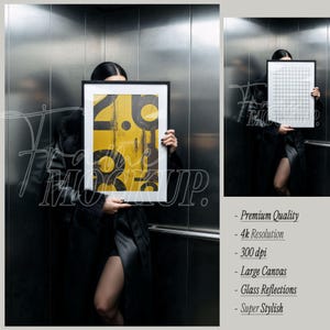 May include: A rectangular black picture frame containing a yellow print with black circular and linear graphic elements. The frame is held up against a metallic elevator wall. A second smaller view shows a white grid pattern inside the same frame.