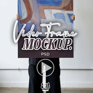 Op de afbeelding: Een abstract schilderij met blauwe, bruine en witte penseelstreken wordt getoond. De woorden "Video Frame Mockup" zijn over de afbeelding geplaatst. Onder de tekst staan het woord "PSD" en een afspeelknop.
