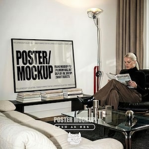 Könnte beinhalten: Ein modernes Wohnzimmer mit einer gerahmten Poster-Mockup-Anzeige mit der Aufschrift "POSTER/MOCKUP". Eine Frau liest ein Magazin in einem schwarzen Ledersessel. Eine Stehlampe und ein Glastisch mit Metallakzenten sind ebenfalls zu sehen.