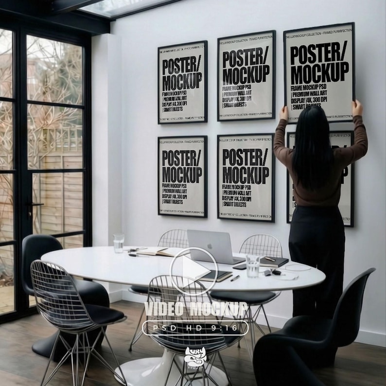 6 A-size frames gallery wall video mockup PSD. A woman hangs black poster mockups in a modern dining room. Premium wall art display for social media.