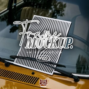 以下が含まれることがあります： ヴィンテージのゴールドカーのフロントガラスに表示されたフレームモックアップ。モックアップは、スタイリッシュなフォントで「Frame Mockup」という言葉が入った白黒ストライプのデザインが特徴です。画像には「4K RESOLUTION」と「(PSD)」の文字も含まれています。