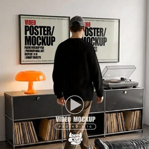 Può includere: Un moderno allestimento di un soggiorno con un mobile nero con dischi in vinile, un giradischi e due poster incorniciati. Una lampada a fungo arancione è sul mobile. I poster recitano "VIDEO POSTER/MOCKUP".