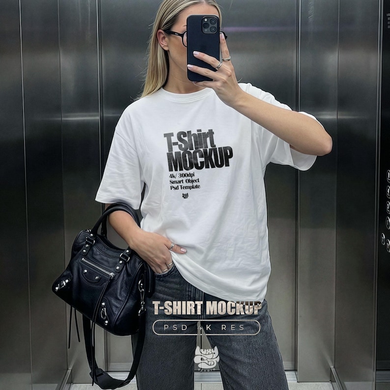Oversized white t-shirt mockup featuring a trendy woman taking a mirror selfie in an elevator, ideal for streetwear brands. tshirt mock up for e-commerce and social media posts.