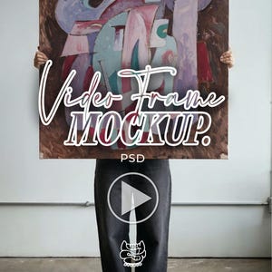 Puede incluir: Se muestra una pintura abstracta con una mezcla de colores, incluyendo marrón, rosa y azul. El texto "Video Frame Mockup" está superpuesto en la obra de arte. Debajo, una persona lleva pantalones vaqueros oscuros y zapatos negros.