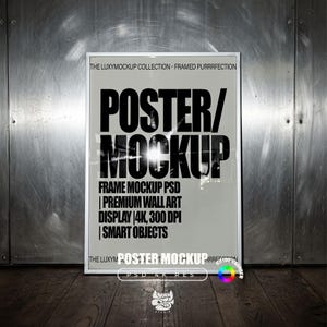 Puede incluir: Una maqueta de póster enmarcado en blanco con el texto "POSTER/MOCKUP" en letras negras grandes. El póster incluye detalles como "FRAME MOCKUP PSD" y "PREMIUM WALL ART DISPLAY". El fondo es una pared metálica y un suelo de madera.