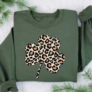 May include: A green sweatshirt with a leopard print shamrock design.