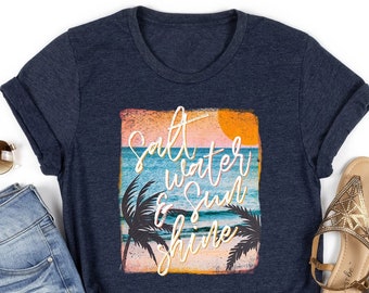 May include: A navy blue t-shirt with a graphic print of a sunset over the ocean with palm trees and the text "Salt Water & Sunshine".