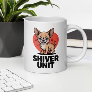 May include: White ceramic mug featuring a cartoon chihuahua with a red heart background. The chihuahua is light brown with large eyes and the text "SHIVER UNIT" in black below the dog. The mug has a curved handle.