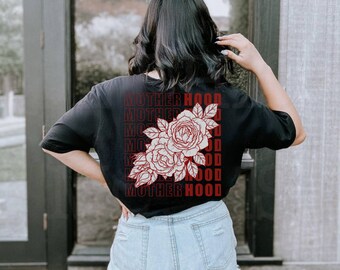 Puede incluir: Camiseta negra con un gráfico rojo de una rosa y la palabra "MOTHERHOOD" repetida varias veces.