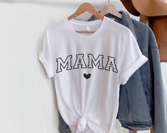Puede incluir: Camiseta blanca con texto negro que dice "MAMA" con un pequeño corazón negro debajo.