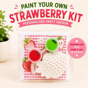 May include: A paint your own strawberry kit in a clear plastic bag. The kit includes a white strawberry-shaped figure, two small paint pots in red and green, and a card with a red gingham pattern and strawberry illustrations. Text reads: PAINT YOUR OWN STRAWBERRY KIT, PERSONALISED PARTY FAVOUR, and PERSONALISED WITH NAME & AGE ON THE BACK.