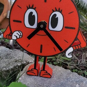May include: A red clock with black hands and white eyes, standing on two legs with red shoes. The clock has a black outline and a textured surface.