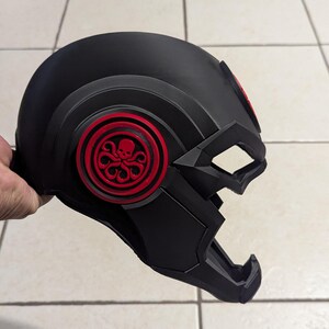 May include: Black helmet with a red Hydra logo on the side. The helmet has a textured surface and a visor.