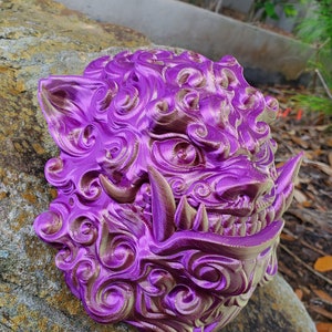May include: A purple and gold 3D printed decorative sculpture of a mythical creature with intricate details. The sculpture is made of plastic and has a textured surface.