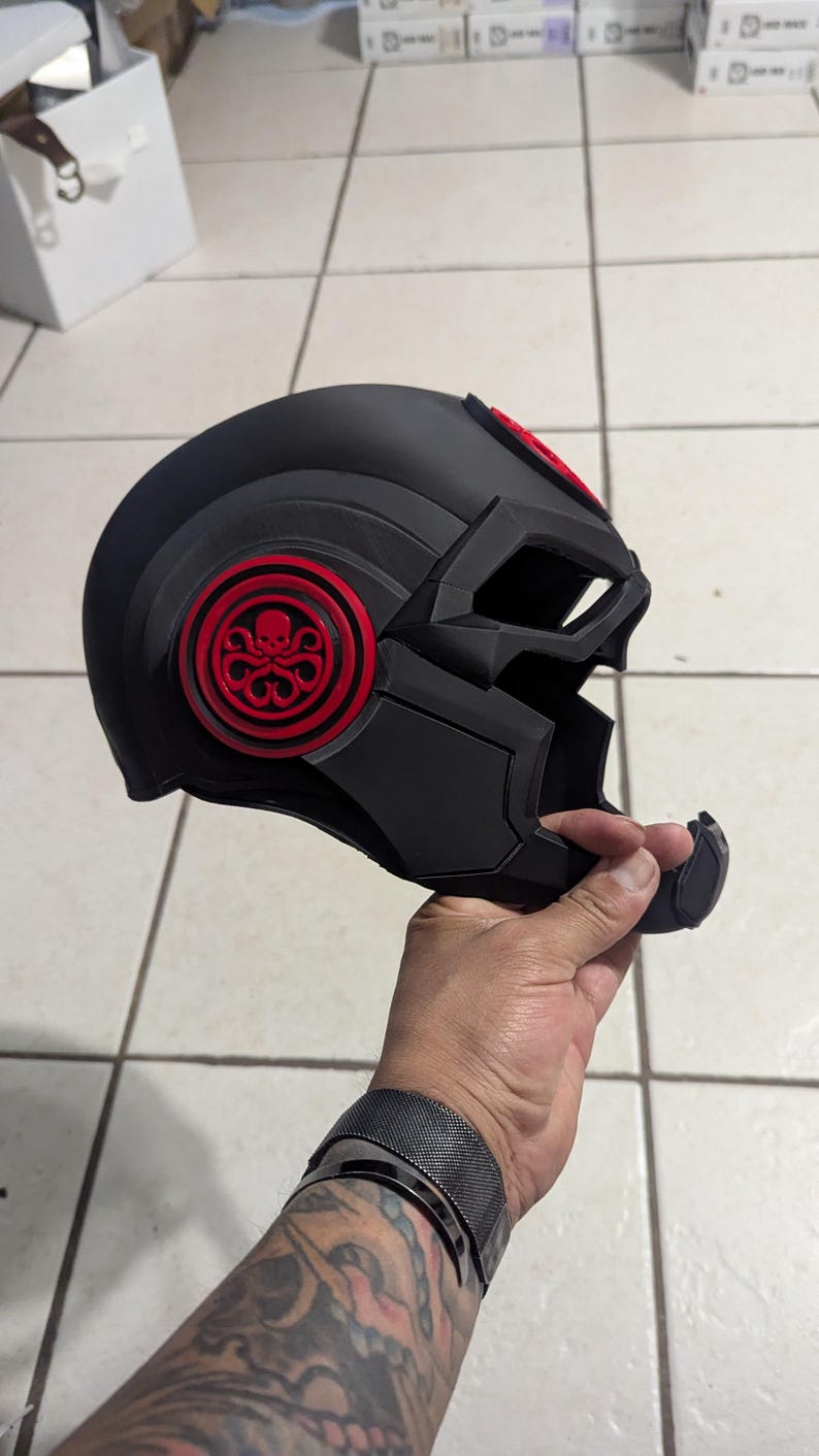May include: A black helmet with a red Hydra logo on the side. The helmet has a visor and a chin guard.