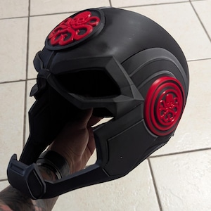 May include: A black helmet with a red Hydra logo on the front and side. The helmet has a futuristic design with a visor and a chin guard.
