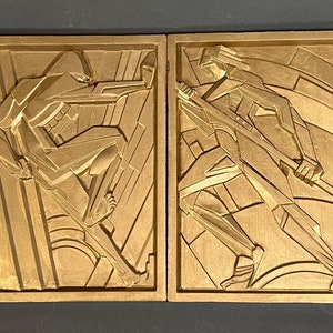Könnte beinhalten: Zwei goldfarbene Art-Deco-Relieftafeln. Eine zeigt eine Figur, die sich ausstreckt, die andere eine Figur, die einen langen Gegenstand hält. Die Figuren sind mit geometrischen Formen und Linien stilisiert, vor einem Hintergrund aus vertikalen und abgewinkelten Linien.
