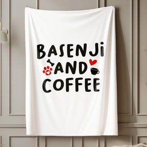 May include: White rectangular wall hanging with the text "BASENJI AND COFFEE" in black. The word "BASENJI" is above "AND COFFEE". A red paw print, bone, heart, and coffee cup are between the words. The wall hanging is displayed on a wall.