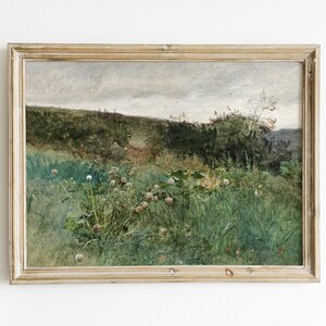 May include: An antique landscape painting in a gold-toned wooden frame. The artwork depicts a field of tall green grass and wildflowers under a cloudy sky. The painting has a vintage aesthetic, with muted colors and visible brushstrokes.