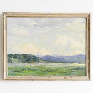 May include: A framed landscape painting depicting a valley with rolling green hills and a cloudy sky. The painting is done in a soft, impressionistic style.