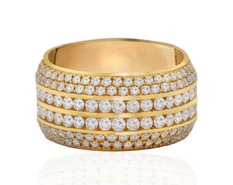 May include: A gold band ring with multiple rows of small, clear diamonds.