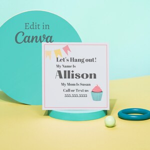 May include: A white card with colorful flags at the top. The text on the card reads "Let's Hang out! My Name Is Allison. My Mom Is Susan. Call or Text us 555.555.5555". A pink and white cupcake with a pink cherry on top is in the bottom right corner of the card.