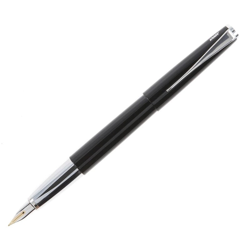 May include: A black fountain pen with a silver clip and a gold nib. The pen has the word "LAMY" engraved on the clip.