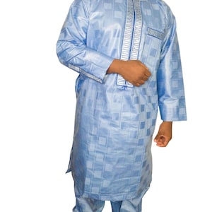 May include: A light blue long-sleeved shirt with a geometric pattern and silver trim. The shirt has a collar and a button-up front. The shirt is paired with matching pants.