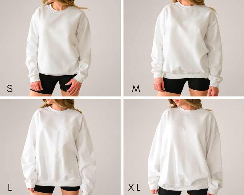 May include: Four white crewneck sweatshirts in sizes S, M, L, and XL. Each sweatshirt is shown on a person wearing black shorts. The sweatshirts have long sleeves and a classic, casual design. The sizes are labeled in black text.