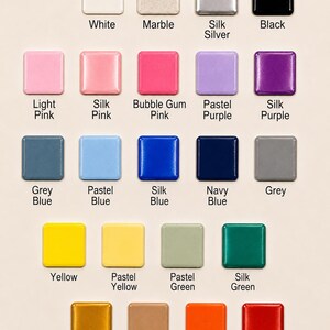 May include: A color chart featuring twenty-two square tiles arranged in rows. Each tile displays a distinct color or finish, including white, marble, silk silver, black, light pink, silk pink, bubble gum pink, pastel purple, silk purple, grey blue, pastel blue, silk blue, navy blue, grey, yellow, pastel yellow, pastel green, silk green, silk gold, light brown, orange, and silk red, with the corresponding name printed below each.