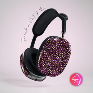 May include: Black and silver over-ear headphones with a purple and gold leopard print design on the earcups. The text "Featured on Air Pods Max" is written in cursive. A pink and red logo is in the bottom right corner.