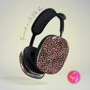 May include: Black over-ear headphones with a gold and purple leopard print design. The text "Featured on Air Pods Max" is written in cursive. The headphones have a black headband and ear cups.