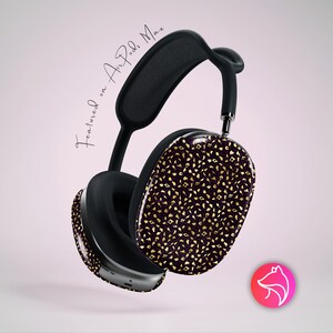 May include: Black and silver over-ear headphones with a patterned design in gold on a dark purple background. The text "Featured on Air Pods Max" is written in cursive. A pink and red logo is in the bottom right corner.