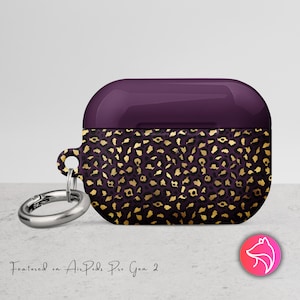 May include: Purple and gold leopard print AirPods Pro Gen 2 case with a silver carabiner clip. The case has a glossy purple top and a textured leopard print pattern on the bottom. The text "Featured on AirPods Pro Gen 2" is written in a script font.