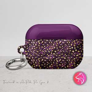 May include: Purple and gold leopard print AirPods Pro Gen 2 case with a silver carabiner clip. The case has a glossy purple top and a leopard print pattern on the bottom. The case is designed to protect the AirPods Pro Gen 2.