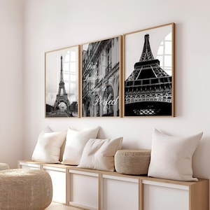 Peut inclure: Trois impressions encadrées en noir et blanc de monuments parisiens. La Tour Eiffel est représentée sur deux impressions, avec une façade de bâtiment sur l'impression centrale. Le texte "But Darlings You're Perfect" est présent. Les cadres sont en bois clair.