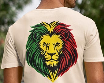 Può includere: T-shirt beige con un motivo di leone colorato sul retro. La criniera del leone è verde, gialla e rossa. La grafica è un'illustrazione dettagliata e stilizzata. La maglietta è a girocollo.